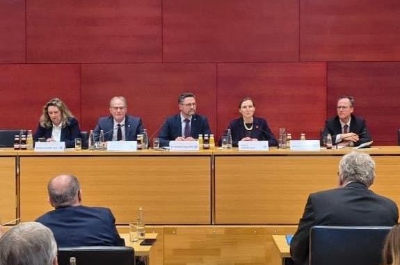 Sicherheitsgipfel Bayerischer Landtag Podiumsdiskussion mit fünf Personen, die an einem Tisch sitzen. Roter Hintergrund.